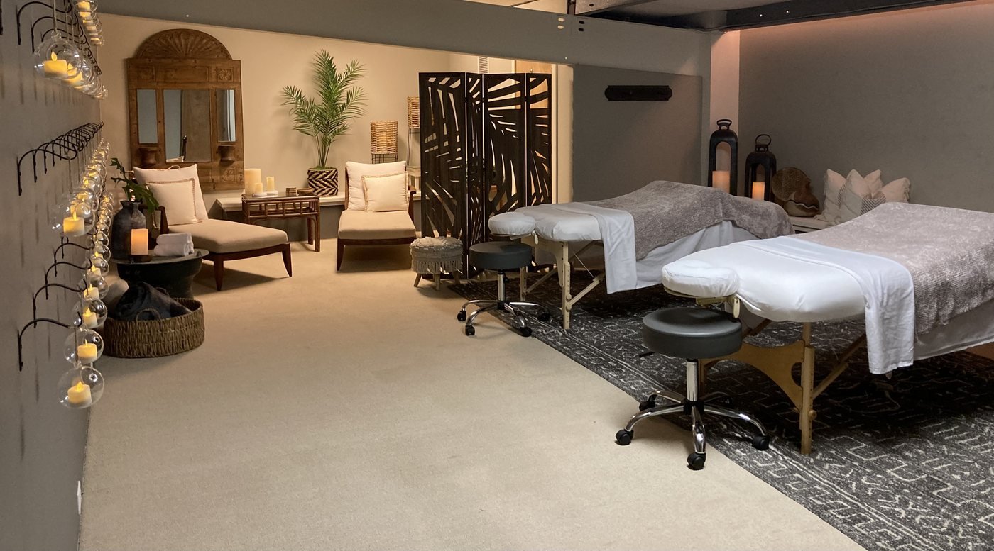 Warm candlelit couples loft with a treatment bed and natural wood decor