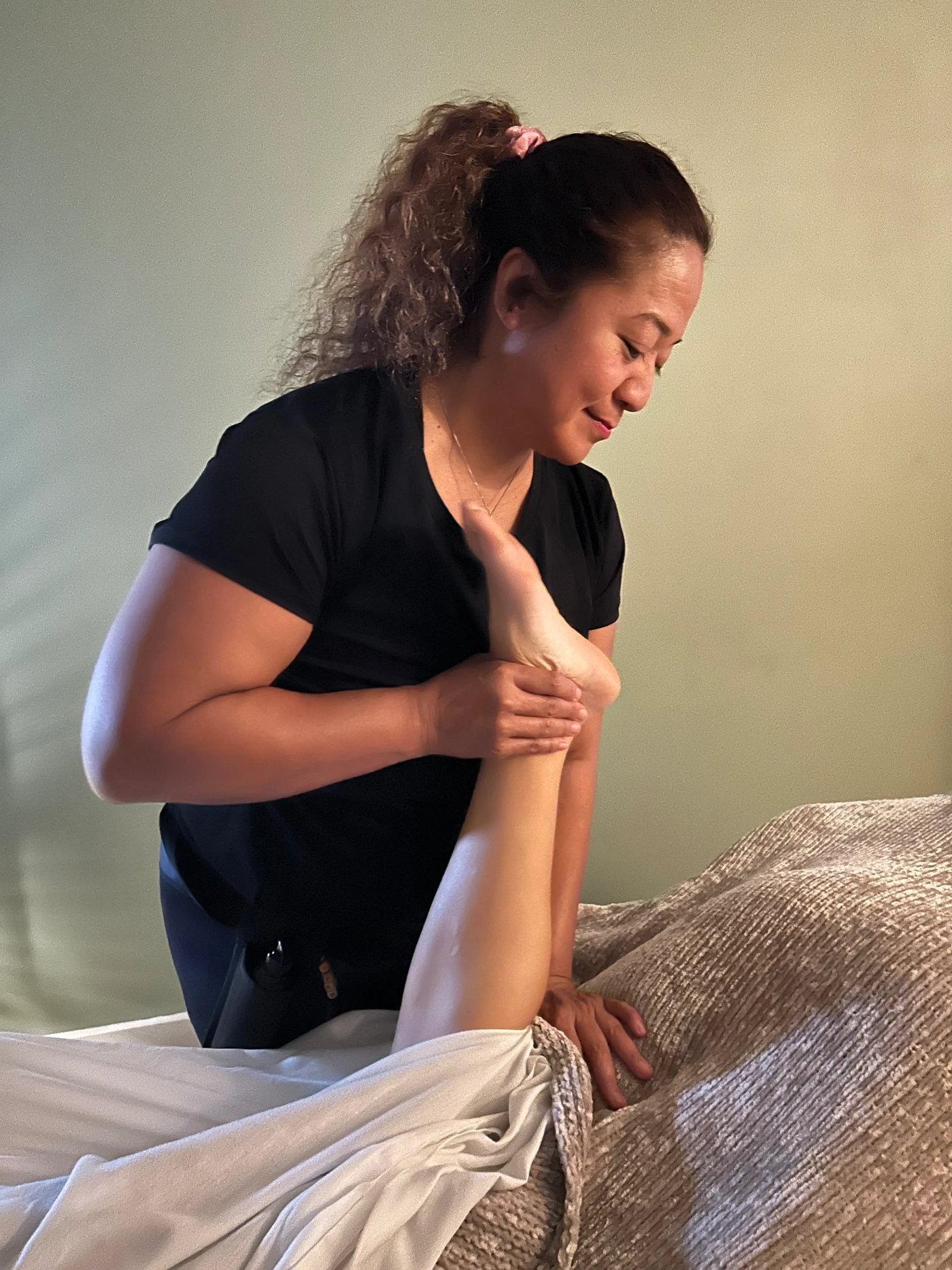 Massage on a table set up on a Kona beach with the surf just beyond